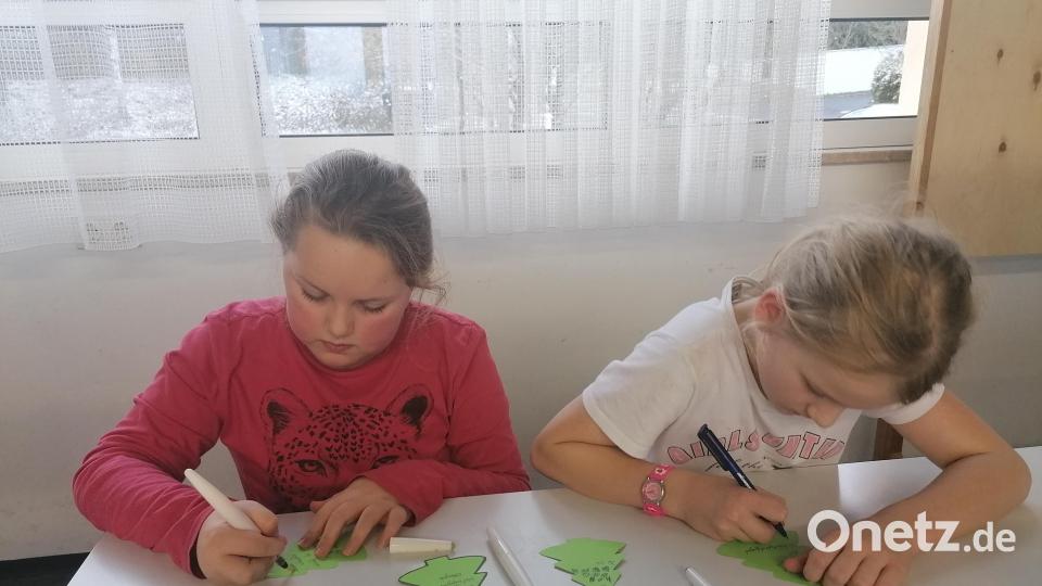 Nach dem Verpacken der Plätzchen wurden die Tüten noch mit weihnachtlichen Anhängern geschmückt; diese wurden zuvor von den Kindern und Jugendlichen beschriftet. Bild: Pia Lang/exb