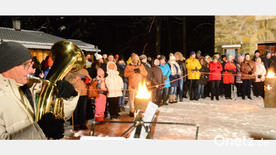 Viele Besucher der OWV-Waldweihnacht am Fischerberg stehen um das Schwedenfeuer. Bild: Kunz