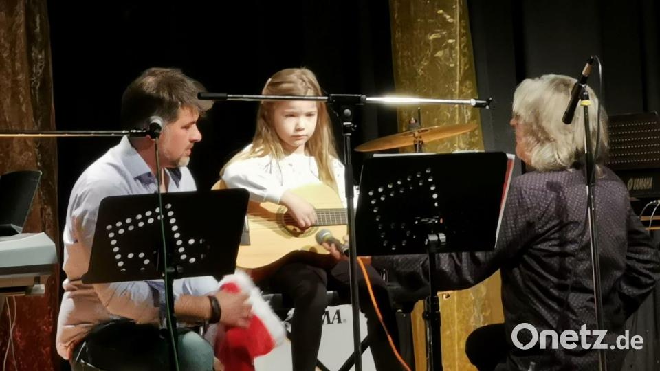 Im Beisein von Vater Thomas Höreth und Musiklehrer Jürgen Rohr trägt Kathleen Höreth mit der Gitarre als eine der jüngsten Musikerinnen die Melodie &quot;Lasst uns&quot; vor. Bild: gz