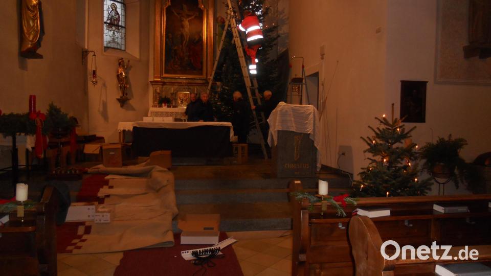 Alexander Klettner (auf der Leiter) ist der Dienstälteste der Feuerwehrtruppe, die seit Jahren den Baum in der katholischen Kirche in Flossenbürg schmückt. Bild: jba