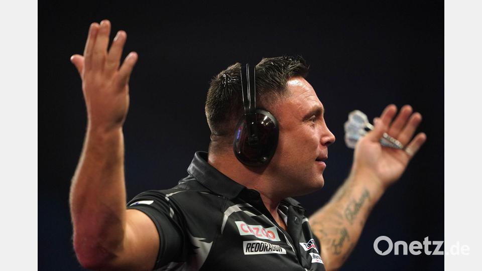 Gerwyn Price kam nach einer Werbepause mit riesigen Kopfhörern auf die Bühne zurück. Bild: Zac Goodwin/PA Wire/dpa