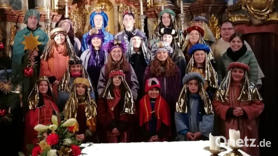 Die Sternsinger versammeln sich mit Pfarrer Markus Urban am Altar der Pfarrkirche Dieterskirchen. Bild: mad