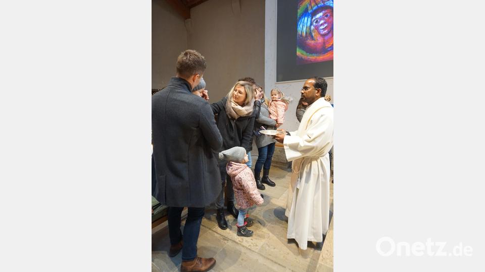 Die Eltern segnen ihre Kinder mit Weihwasser in Erinnerung an deren Taufe . Mit Pfarrer Sagaiaraj Lourdusamy (rechts) Bild: wec