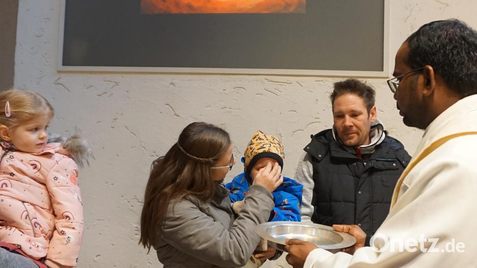 Vor den Augen von Pfarrer Sagaiaraj Lourdusamy (rechts) segnen die Eltern ihre Kinder mit Weihwasser in Erinnerung an deren Taufe. it Bild: wec