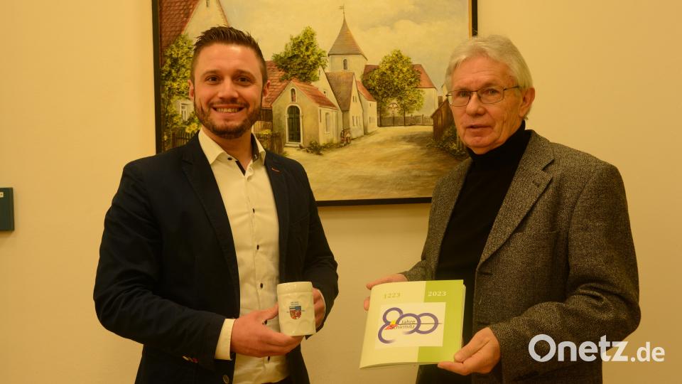 Bürgermeister Ernst Lenk hat die Kaffeetasse in der Hand, die Schirmitz zur Erinnerung an deren 800-jähriges Bestehen anbietet. Altbürgermeister Karl Balk ist für die Festschrift verantwortlich, die in Wort und Bild ausführlich die Geschichte der Gemeinde aufzeigt. Bild: bey