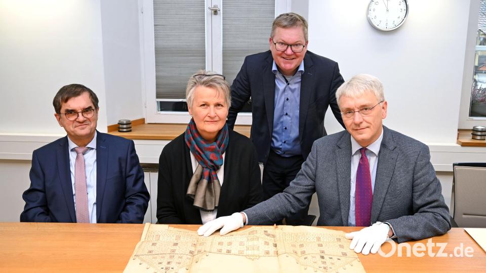 Landgerichtspräsident Stefan Täschner, die Leiterin des Staatsarchivs, Maria Rita Sagstetter, Stadtarchivar Andreas Erb (vorne, von links) und Oberbürgermeister Michael Cerny (stehend) bei der Begutachtung der aus dem 16. Jahrhundert stammenden Zeichnung der Regierungskanzlei, die einst die Vorgängerbehörde des Staatsarchivs und jetzt das Landgericht beherbergt. Bild: Susanne Schwab/exb