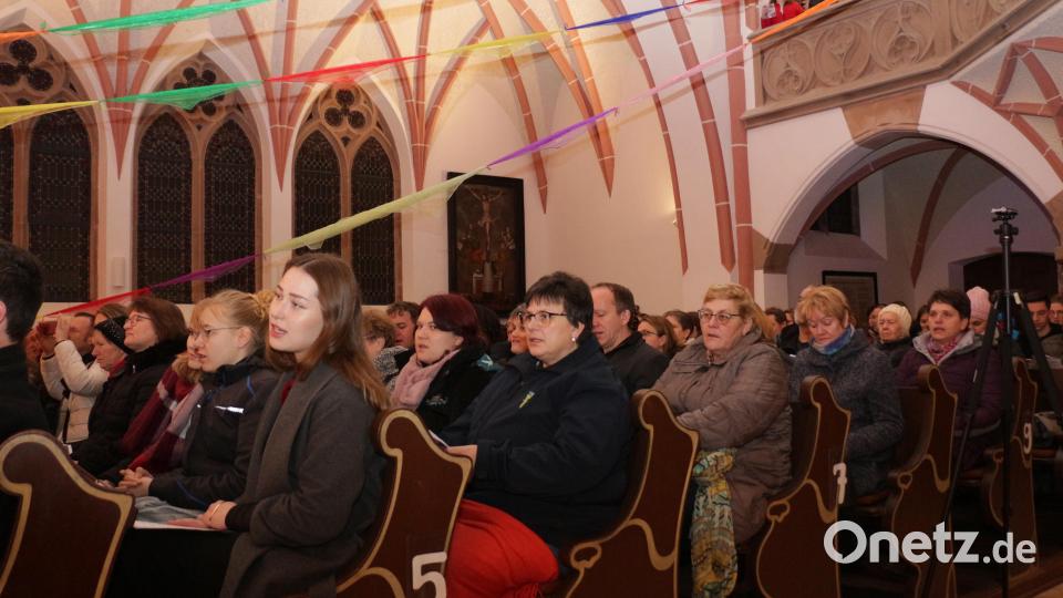 Das Publikum lauschte, sang und applaudierte stets begeistert. Mit bunten Tüchern war im Kirchengebäude ein Friedensnetz angedeutet, passend zum Lied „Verleih uns Frieden gnädiglich“. Bild: rpp