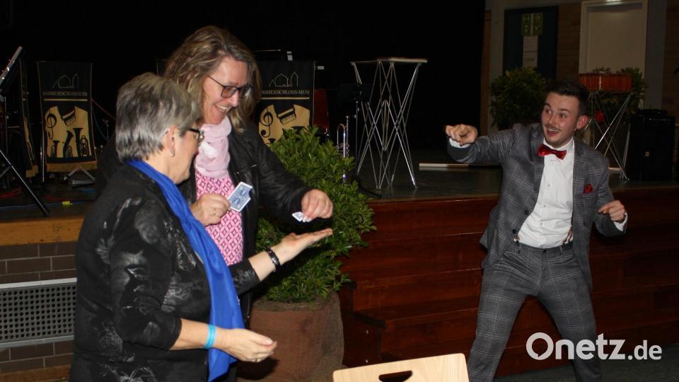 Wie kommt der Schnipsel, den die Trabitzer Bürgermeisterin Carmen Pepiuk (Mitte) auf der Bühne von einer Spielkarte abgerissen hatte, in Christine Pfeiffers geschlossene Faust? Mit seinen undurchschaubaren Illusionskunststücken verblüffte Marius Koslowski die Gäste des Gewerbering-Neujahrsempfangs. Bild: bjp