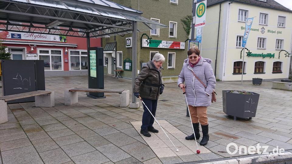 Maria Röber (links) und Eleonore Weigl sind durch die altersbedingte Makuladegeneration erblindet. Sie finden die taktilen Leitstreifen an der barrierefreien Bushaltestelle am Unteren Markt in Mitterteich hilfreich. Bild: lue
