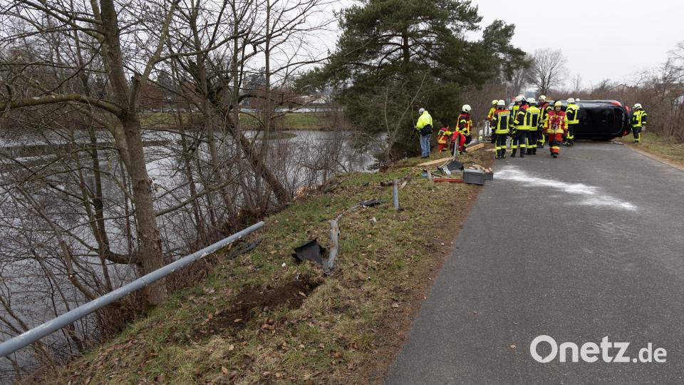 Rettungskräfte ziehen bei Pressath ein Unfallauto aus dem Wasser. Bild: Roland Wellenhoefer