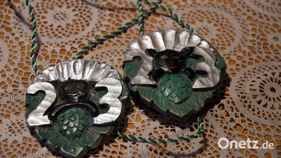 Der handgeschnitzte Neustädter Zoiglorden 2023 zeigt vor dem Hintergrund eines Hopfenblattes die Zutaten fürs Bierbrauen: die Muschel als Symbol für das Wasser, die Hopfendolde und das Wappentier des Neustädter Faschingsvereins, den schwarzen Kater, der das Malz gefressen hat. Bild: Gabi Schönberger