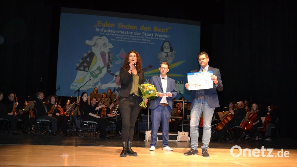 Tanja Hochholzer von der Sparda-Bank überreicht an den Elternbeiratsvorsitzenden Peter Trottmann einen Scheck über 750 Euro. Leiter Thorsten Willecke (Mitte) freut sich auf ein gesponsertes Instrument. Bild: kki
