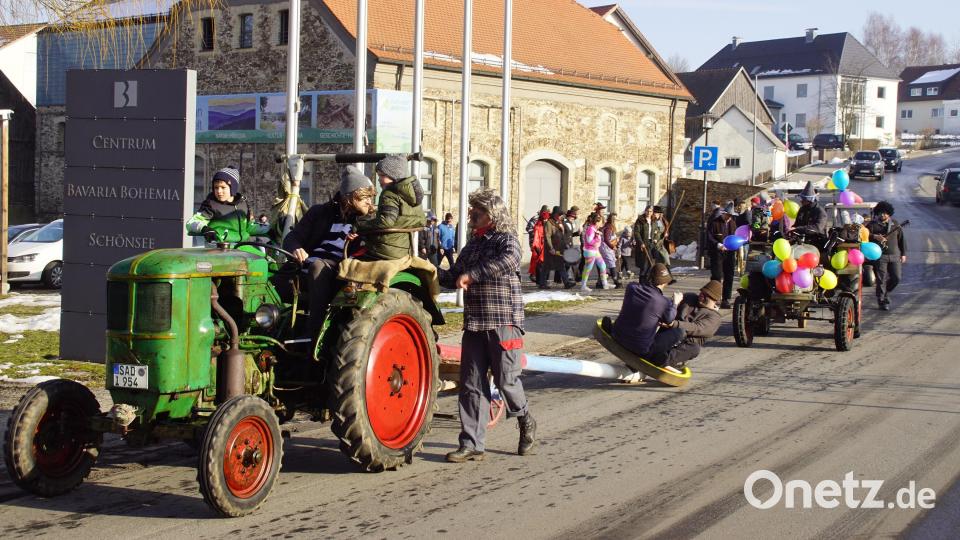 Mit Oldtimer-Bulldogs voran zieht in Schönsee der Tross der Maschkerer vom Feuerwehrhaus Richtung Hauptstraße. Bild: mmj