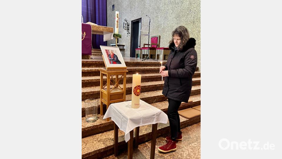 Claudia Meier von der Initiative entzündet eine Kerze mit dem Schriftzug „Ursula“ vor dem Bild der Verstorbenen. Bild: Eichl