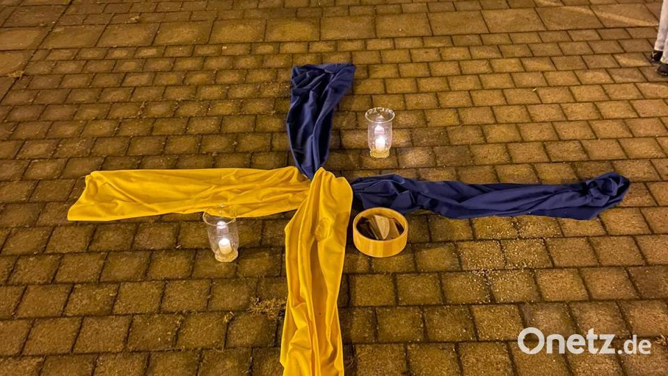 In den Farben der Ukraine gestalten die Organisatoren dazu ein Kreuz auf dem Kirchplatz. Bild: dob