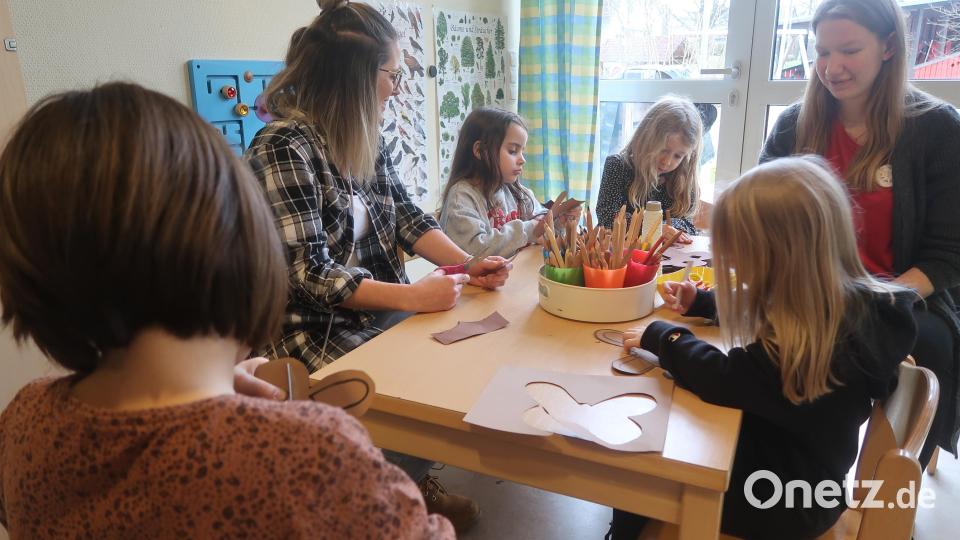 Kinder basteln mit Betreuerinnen Frühlingsmasken. Bild: Kunz