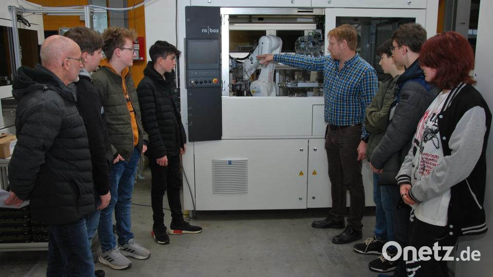Lothar Mauel, Ausbilder bei Baumann GmbH, erklärt den Achtklässlern der Mittelschule Ursensollen mit Lehrer Raimund Rückert (links) eine Anlage zur Erzeugung von Wasserstoff. Bild: gsp