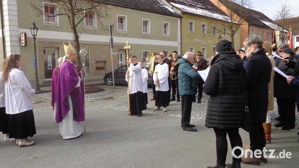Der Bischof wird schon am Marktplatz vom Kirchenchor und der Blaskapelle begrüßt Bild: amö