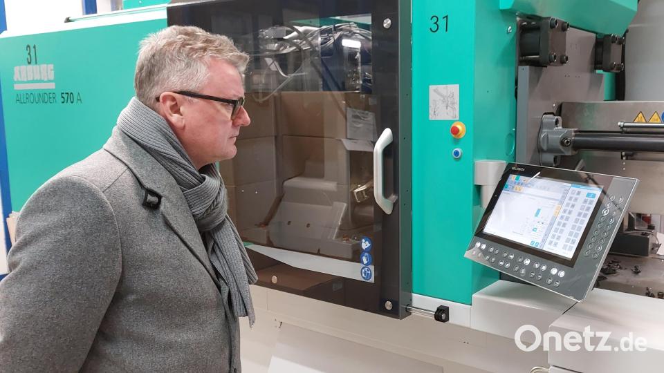 Bürgermeister Michael Göth schaut auf die Bedienungseinheit der großen Spritzgussmaschine Arburg Allrounder 570 S. Bild: mfh