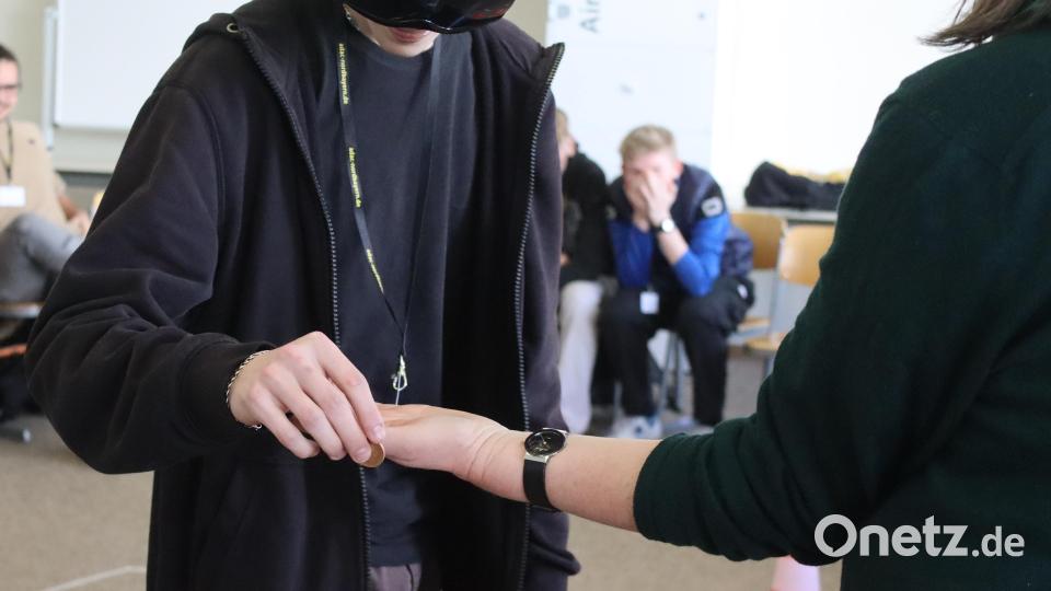 Wie schwer es ist, Position und Abstand der Hände im Raum abzuschätzen, zeigt der Übergabetest. Statt in der Hand der Trainerin landet die Münze auf dem Boden. Bild: mfh