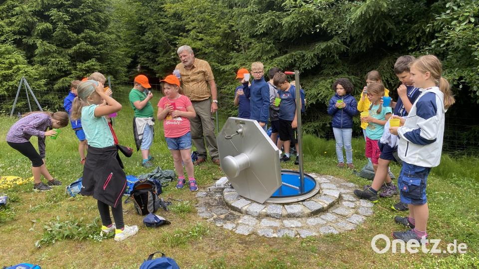 Gewässerschutzbeauftragter Lothar Kroll zeigt den Schüler den &quot;Kochlöffelbrunnen&quot; und lässt sie das Quellwasser probieren. Archivbild: Josef Glas