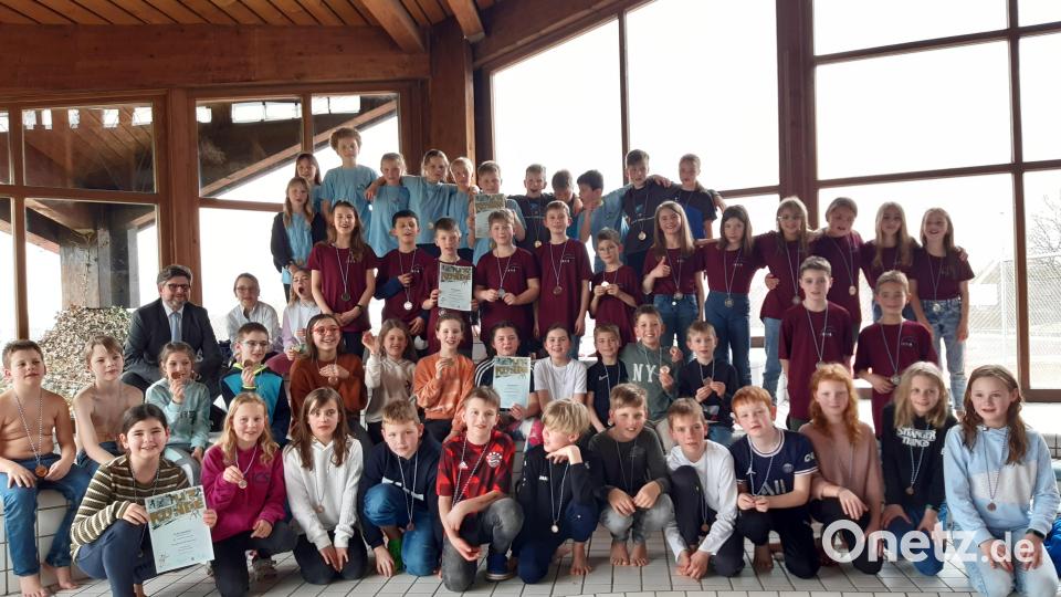Beim Schul-Schwimmfest setzte sich von den größeren Grundschulen die Mannschaft aus Waldsassen (obere Reihe) vor (jeweils darunter) Mitterteich, Tirschenreuth, Ebnath-Neusorg und Erbendorf durch. Schulamtsdirektor Armin Engel (links, Mitte) gratulierte. Bild: rbg
