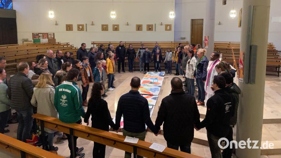 Sich an den Händen haltend, beten die Gläubigen das Vater unser. Bild: Thomas Kreinhöfner/exb