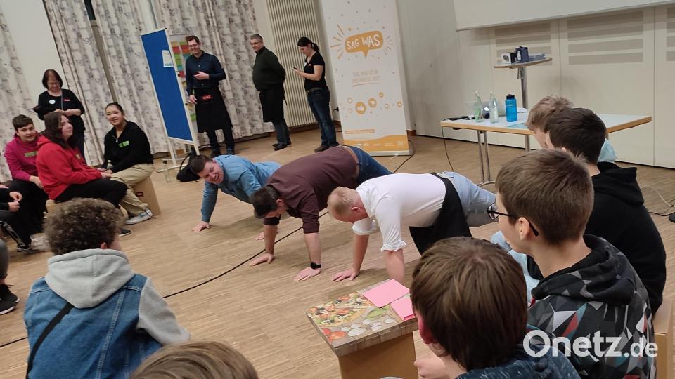 Bürgermeister Marcus Eichenmüller und die Jugendbeauftragten Thomas Hottner und Daniel Hutzler lösen mit Liegestützen eine Wettschuld ein. Bild: Sabine Weber/exb