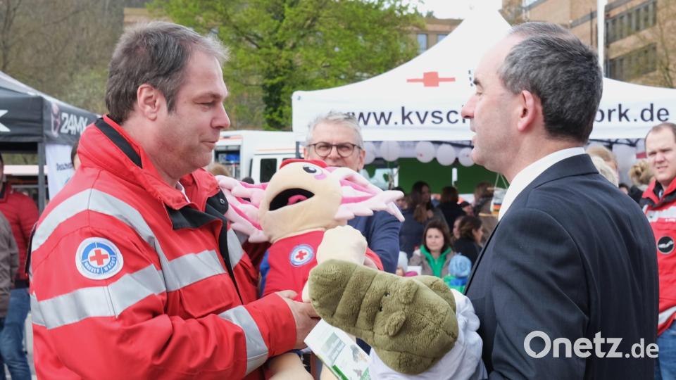 Markus Seitz von der Wasserwacht überreicht Hubert Aiwanger die Maskottchen Klausi und Lotti. Bild: Hirsch