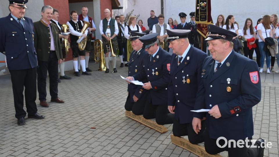 Die spitzen Holzscheite drücken sich schmerzhaft in die Kniescheiben der Steiner Feuerwehrmänner mit Kommandant Karl Striegl, Festleiter Wolfgang Strehl, stellvertretendem Kommandant Josef Ram und Vorsitzendem Christian Schmid (kniend, von links). Der Böhmischbrucker Vorsitzende Reinhard Wiesent und Bürgermeister Andreas Wutzlhofer (von links) hören sich mit den vielen Gästen die Bitte der Steiner an. Bild: dob