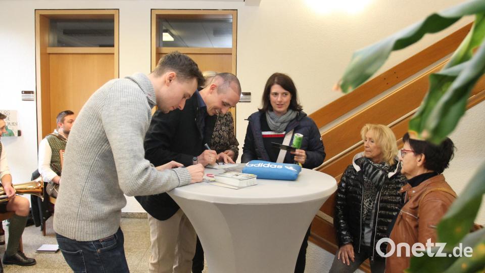 Terence Weber und Eric Frenzel (von links) schreiben fleißig Autogramme. Bild: pi