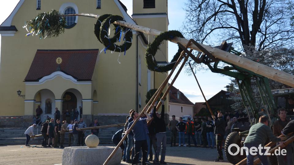 Mit Muskelkraft stellten die KLJB-Mitglieder mit den Männern aus dem Ortsteil den Maiboten auf dem Dorfplatz auf. Bild: dob
