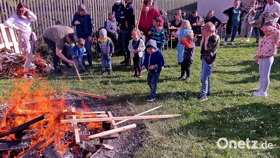 Die Kinder werfen Holzscheite ins Lagerfeuer. Bild: R. Kreuzer