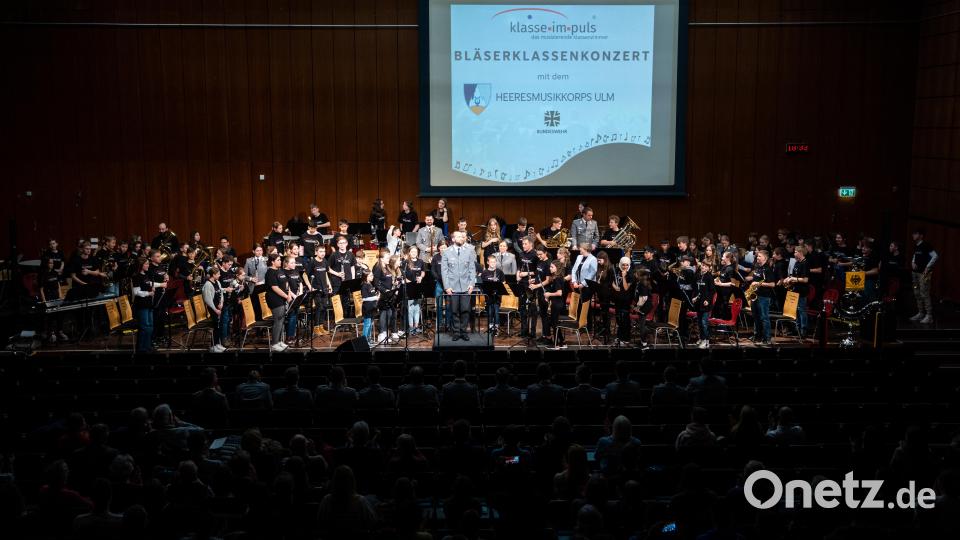 Über hundert Beteiligte auf der Bühne der Aula der Friedrich-Alexander-Universität Nürnberg, mitten darunter die Bläserklassen der Pirker Mittelschule. Bild: Maximilian Böhm/exb
