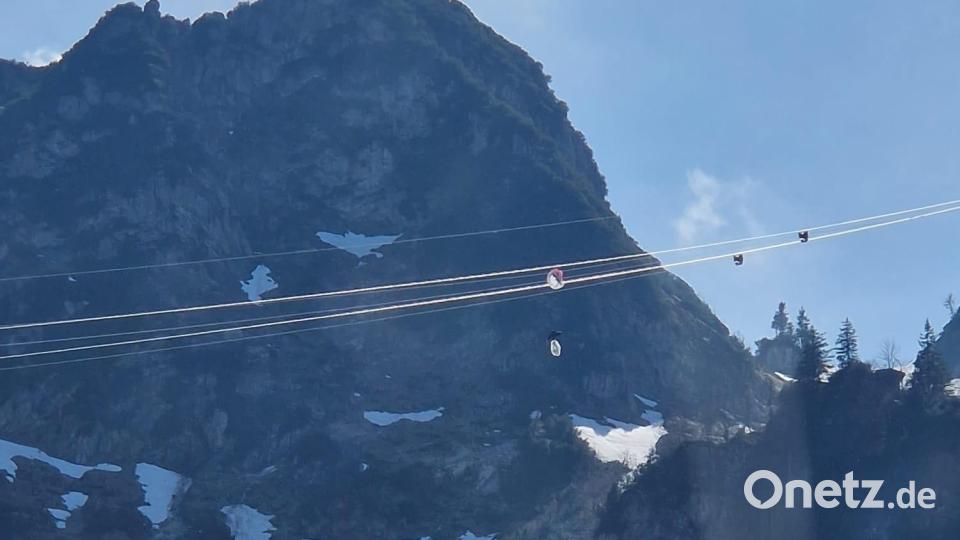 Ein Gleitschirmflieger hängt in den Seilen einer Seilbahn in Oberbayern. Der Mann hatte sich an der höchsten Stelle der Hochfelln-Seilbahn in Bergen im Chiemgau rund 80 Meter über dem Boden mit seinem Fluggerät in den Stahlseilen verfangen. Bild: Bergwacht Bayern/BW Bergen/dpa