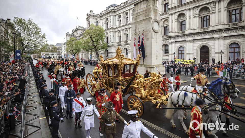 König Charles III. grüßt die Menge, als er und Königin Camilla nach ihrer Krönungszeremonie in der Westminster Abbey in der goldenen Staatskutsche zum Buckingham Palace fahren. Bild: Rob Pinney/dpa