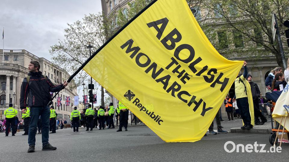 Menschen protestieren am Tag der Krönungszeremonie von König Charles III. gegen die Monarchie, ein Mann schwenkt dabei eine große Fahne mit der Aufschrift "Abolish the Monarchy" Bild: Christoph Meyer/dpa
