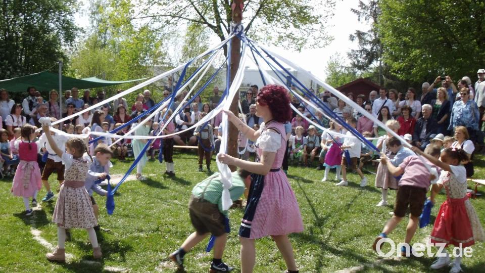 Ein schwieriges Unterfangen haben die Vorschulkinder mit ihrem Bandltanz zu bewältigen. Letztlich schaffen sie es, die vom Maibaumstamm hängenden blau-weißen Bänder im Kreislauf ineinander und wieder auseinander zu flechten. Bild: u
