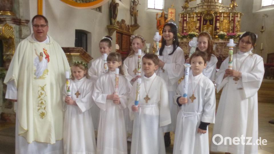 Pfarrer Markus Urban spendet neun Kindern das Sakrament der Erstkommunion. Bild: mad