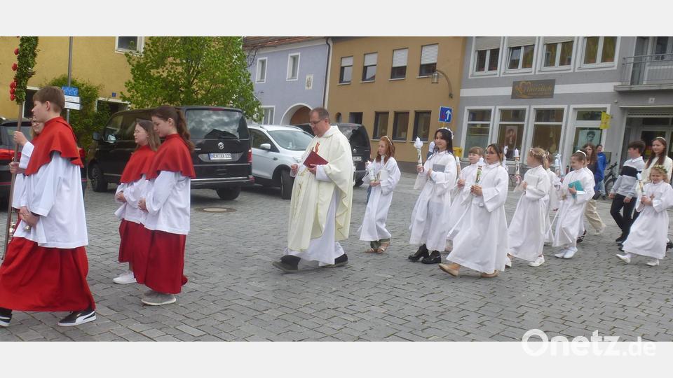 Pfarrer und Ministranten begleiten die Kommunionkinder. Bild: mad