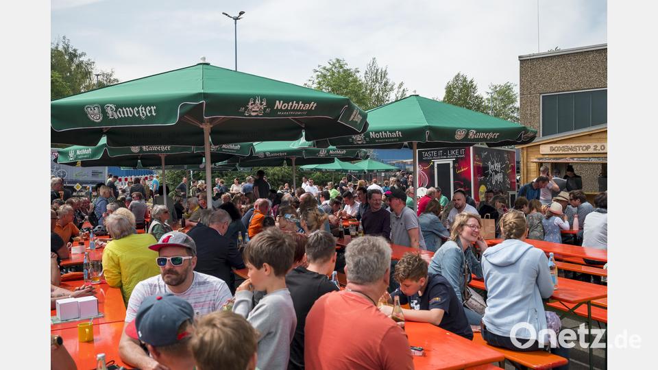 Besucher und Besucherinnen sitzen bei den 1. Bayerischen Schneepflugmeisterschaften in der Sonne und unter Sonnenschirmen. Bild: Daniel Vogl