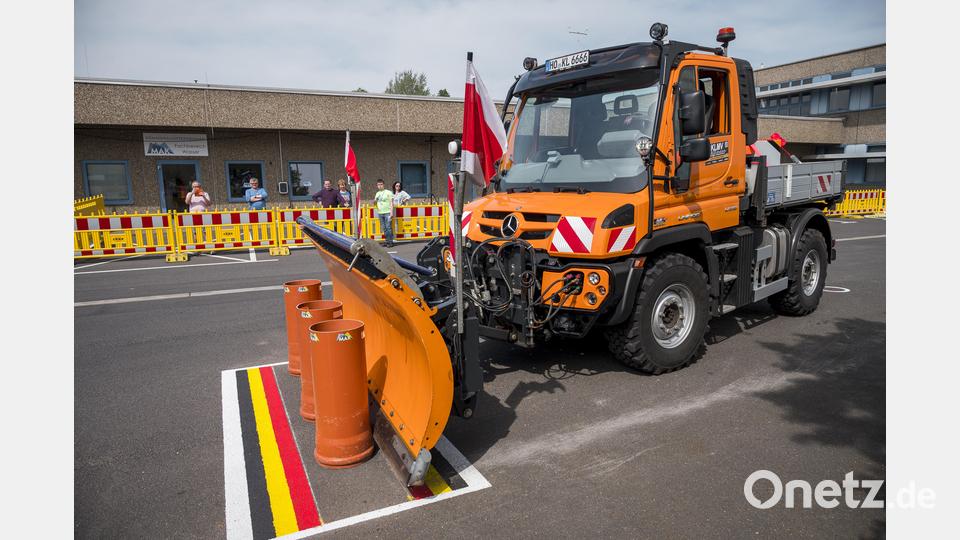 Ein Schneepflug schiebt drei Rohre in einen markierten Bereich. In der Mitte gibt es am meisten Punkte. Bild: Daniel Vogl/dpa