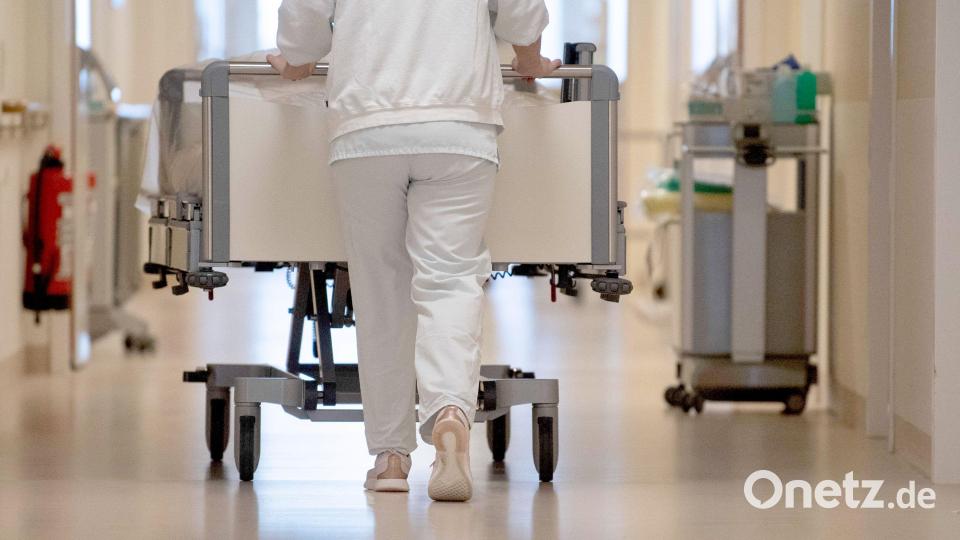 Eine Krankenpflegerin schiebt ein Krankenbett durch einen Flur - auch das gehört zum Alltag einer Pflegekraft. Nur: Die werden immer weniger. Symbolbild: Marijan Murat/dpa