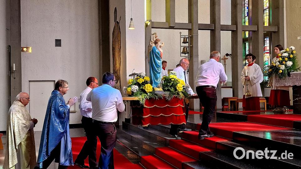 Vier Mitglieder der Kolpingsfamilie tragen die Statue „Maria Königin“ in die geschmückte Kirche Bild: R. Kreuzer