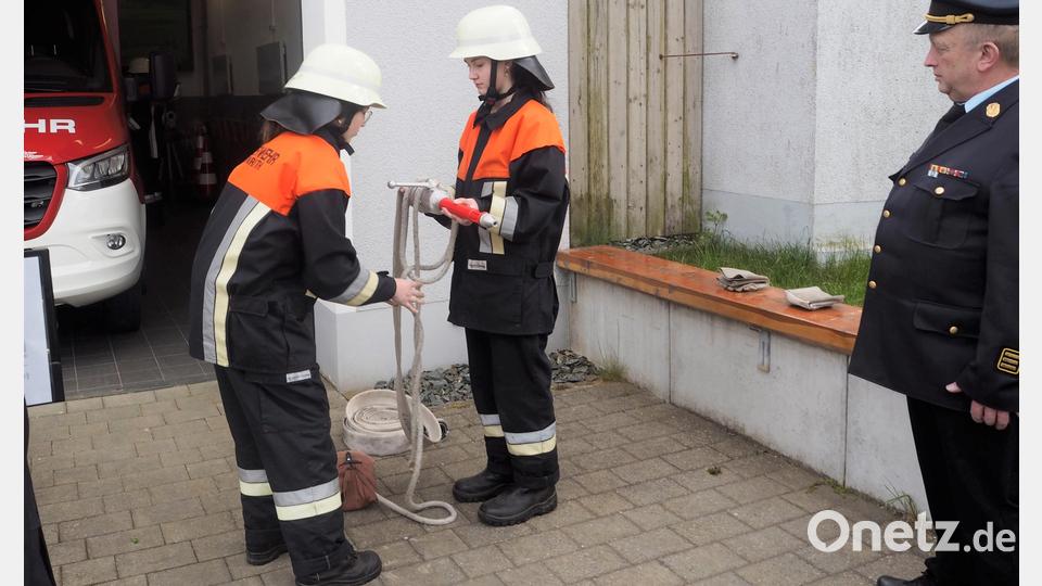 Luisa Neuber (rechts) und Theresa Gollwitzer (links) befestigen für die Prüfung eine Feuerwehrleine am Strahlrohr. Bild: fvo