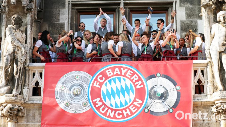 Spielerinnen und Spieler von Bayern München jubeln auf dem Rathaus-Balkon. Bild: Karl-Josef Hildenbrand/dpa