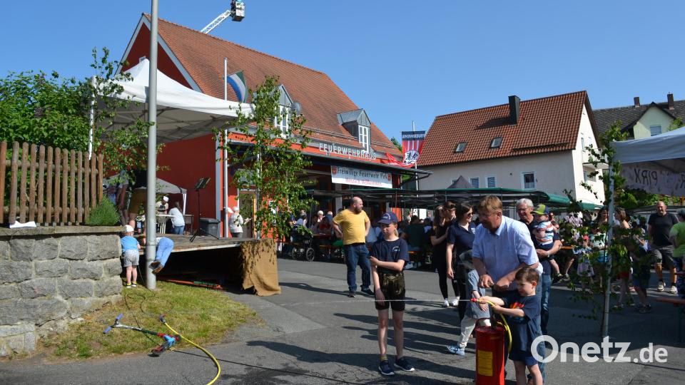 Während sich die Kleinsten beim Löschen mit der Handspritze versuchen, schweben beim Feuerwehrfest in Pirk Wagemutige hoch oben über dem Feuerwehrhaus und genießen die Aussicht. Bild: kki