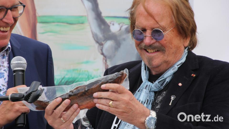 Frank Zander erhielt eine eingeschweißte Forelle als Geschenk aus den Händen von Bürgermeister Franz Stahl. Bild: kro
