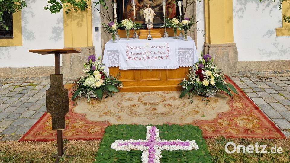 Den Blumenteppich beim ersten Altar vor dem Finanzamtsportal neben dem Kriegerehrenmal hatten die Mitglieder der Kolpingsfamilie gestaltet. Bild: hmr