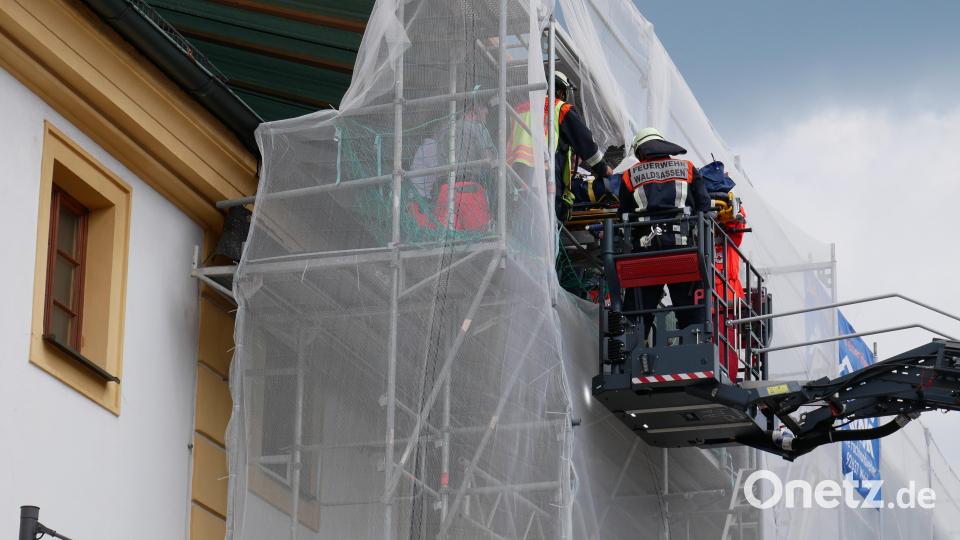 Zentimetergenau steuerte die Besatzung der Feuerwehrdrehleiter den Rettungskorb in das Baugerüst am Gebäude der Stadtbücherei, um die verletzte Person auf der Trage nach unter zu bringen. Bild: hmr